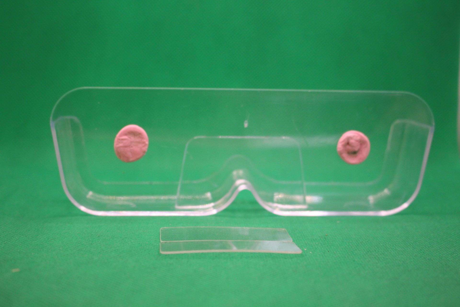 wall mounted eyeglasses holder with sticky tacky putty, and unused adhesives in front