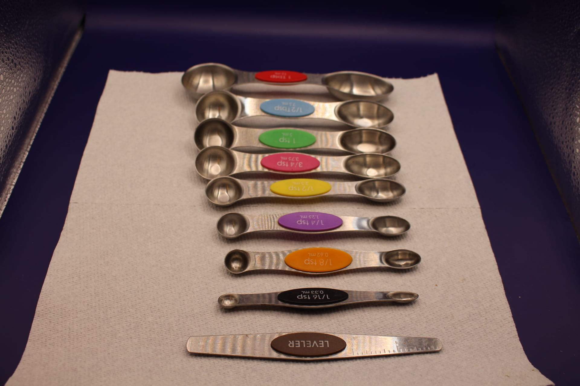 double-sided magnetic measuring spoon set with leveler tool, with smallest spoon displayed in front 