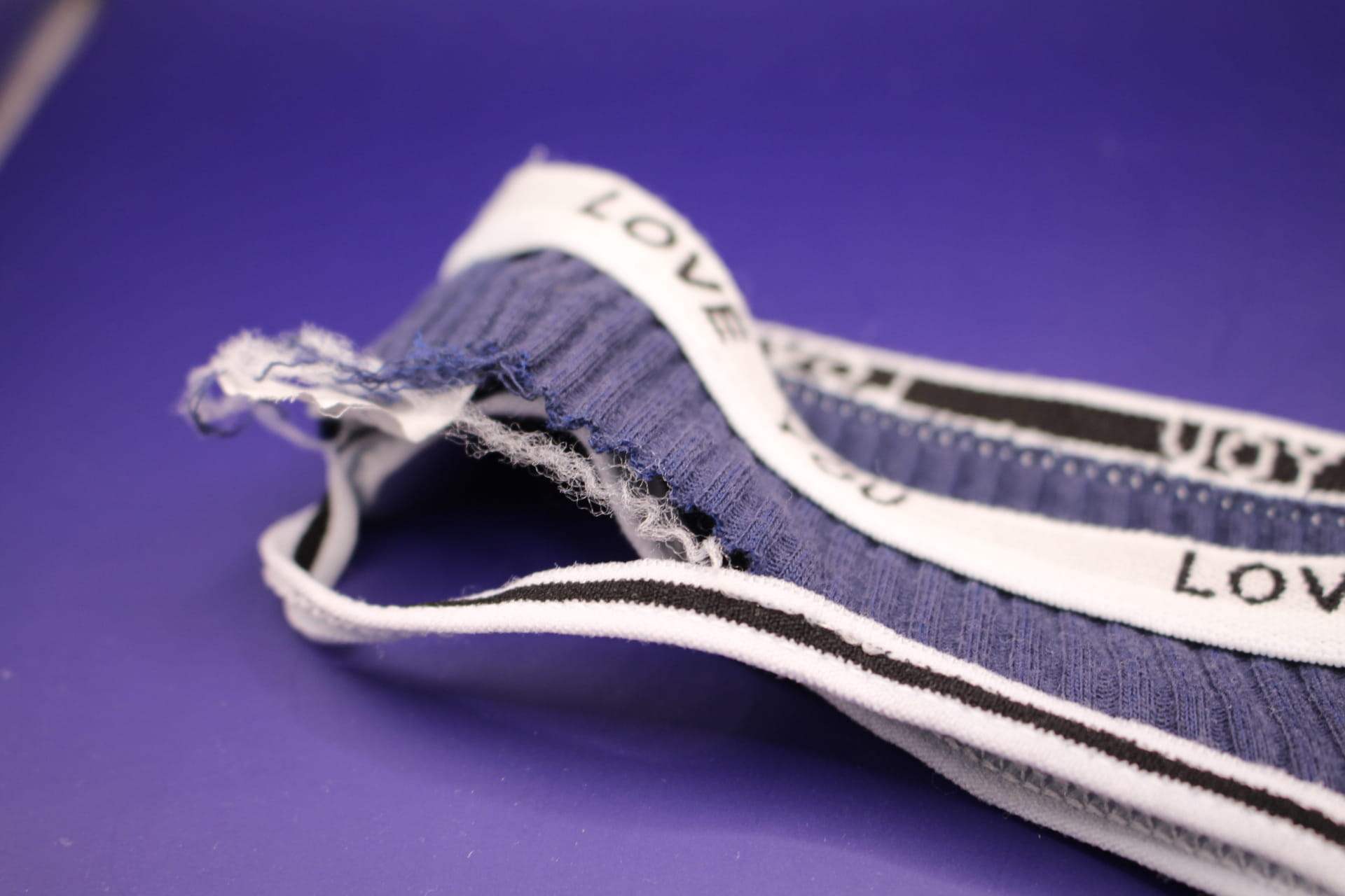 close-up of rip in navy blue LOVE YOU panties from Temu