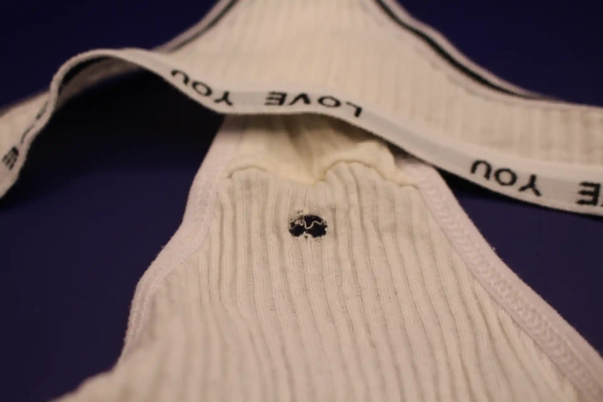 close-up of hole in cream colored LOVE YOU panties from Temu