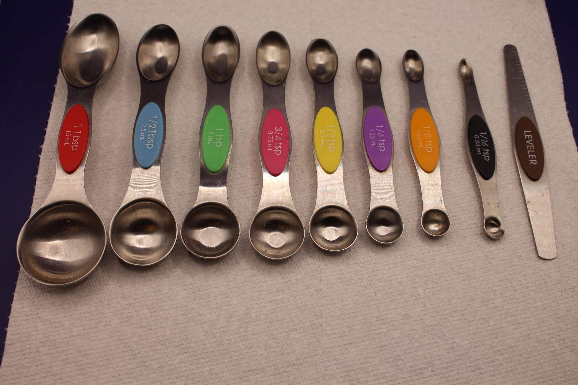 dual-sided magnetic measuring spoon set with leveler tool, displayed from largest to smallest