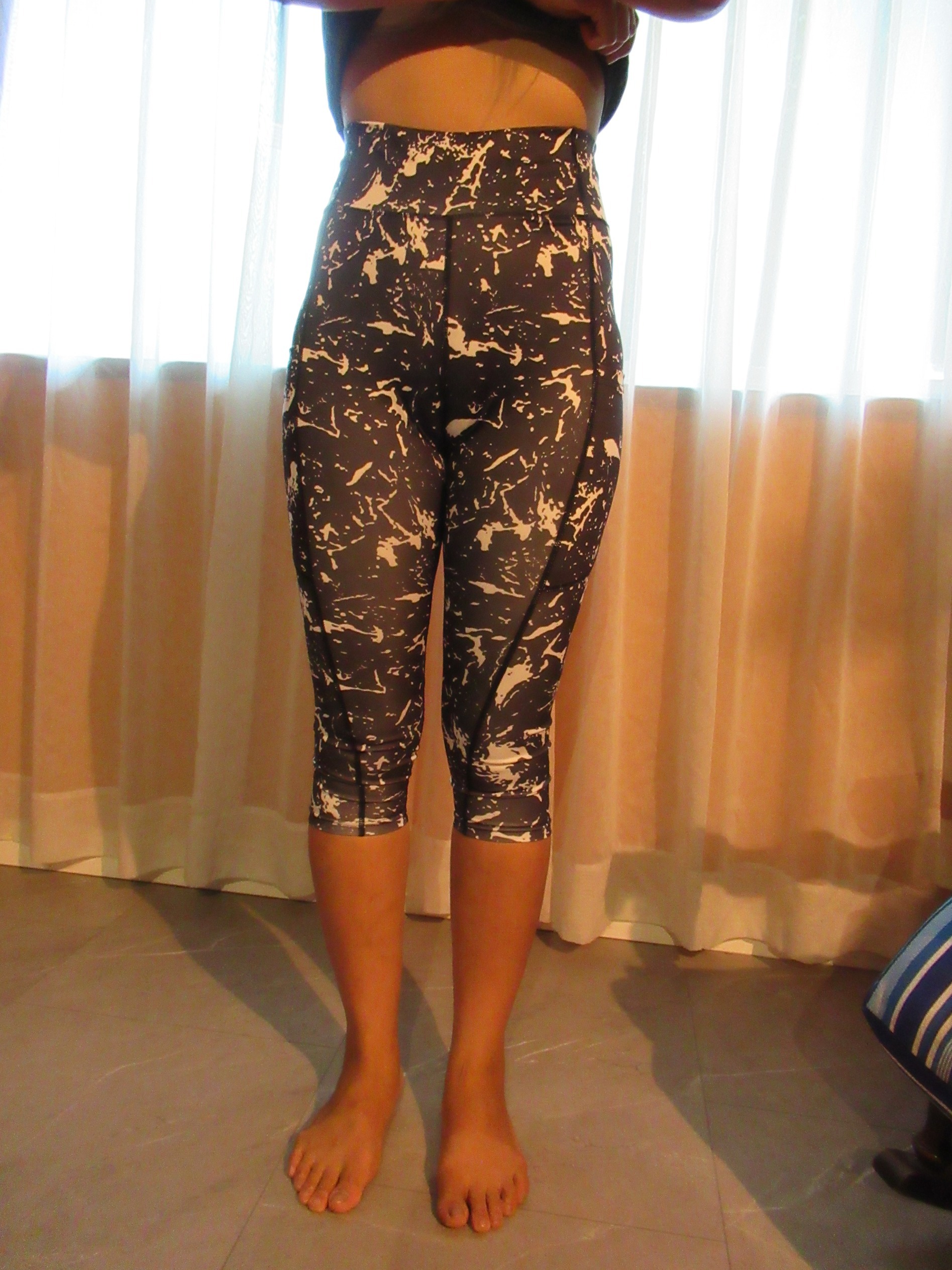 butt-lifting capri pants with big pockets set of three -- black with white splash design, front view; trying on, modelling butt-lifter capris on person