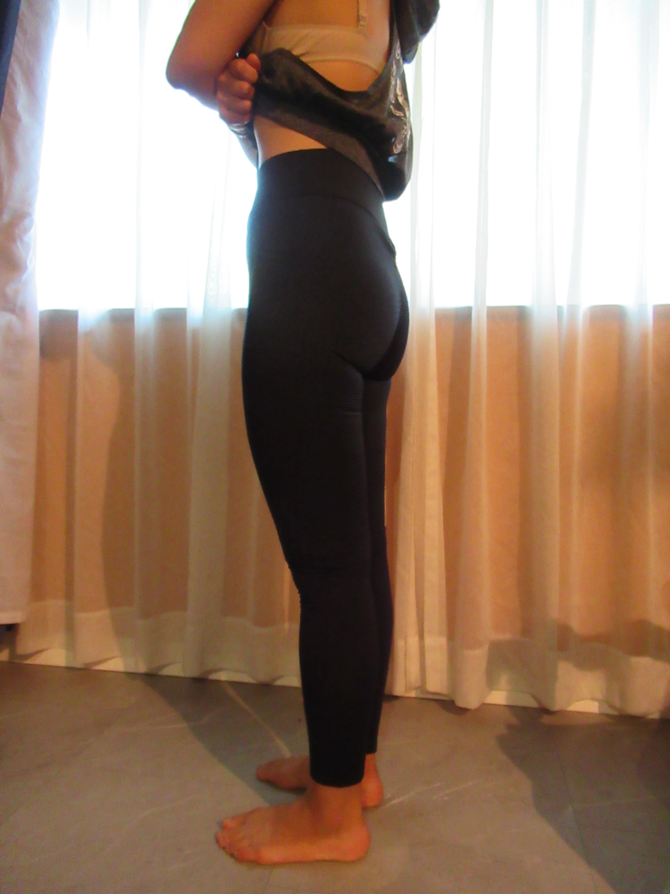 Honeycomb-textured scrunch butt butt-lifting pants -- black, left side view; trying on, modelling honeycomb-textured, scrunched butt-lifter on person