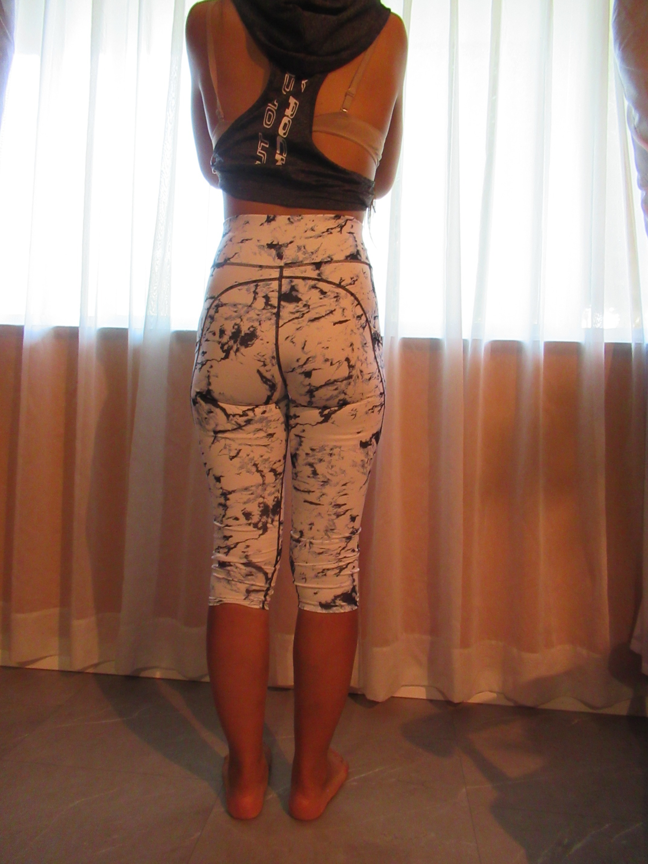 butt-lifting capri pants with big pockets set of three -- white with black splash design, back view; trying on, modelling butt-lifter capris on person