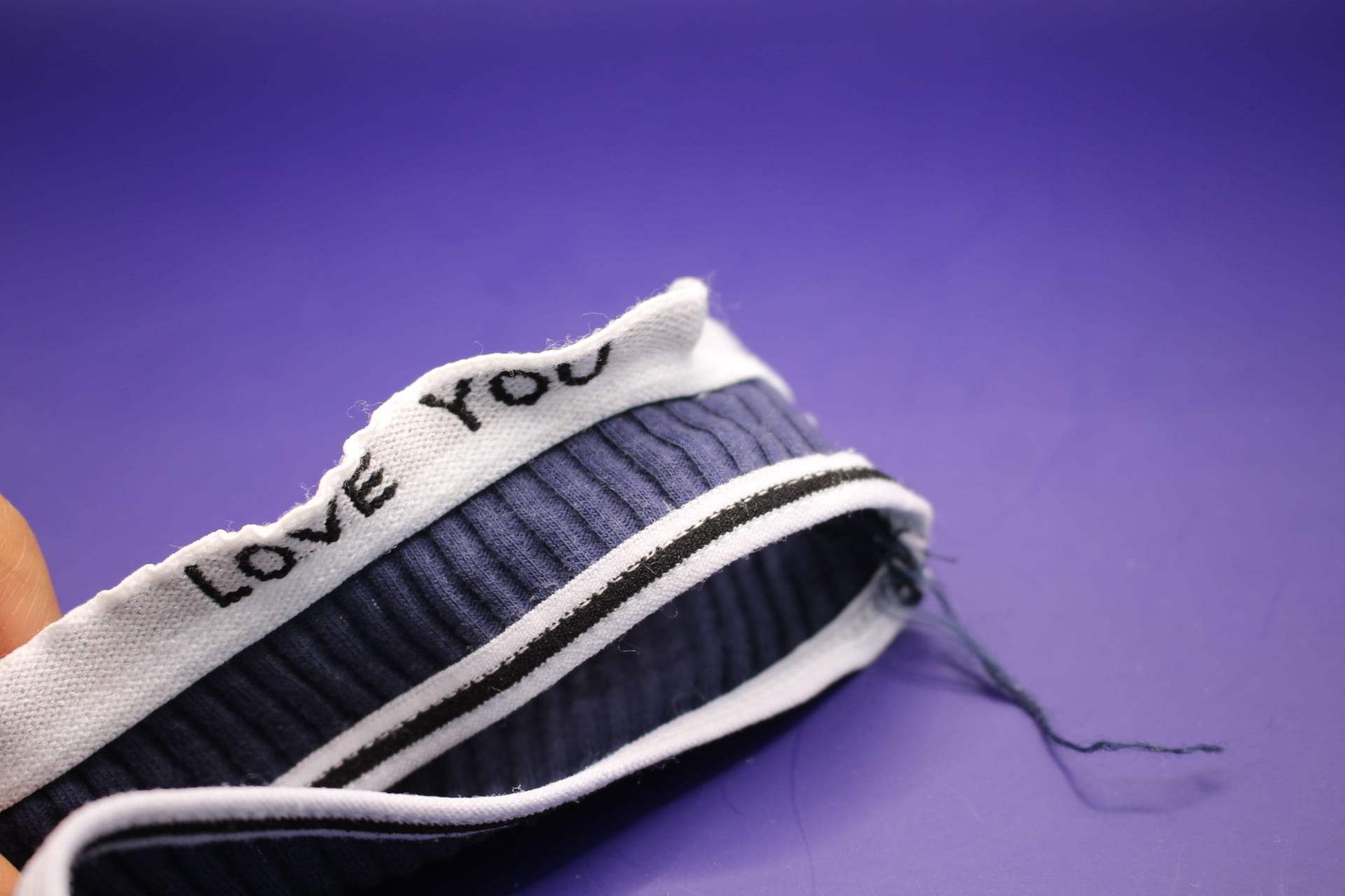close-up of loose thread in navy blue cotton LOVE YOU panties for women from Temu