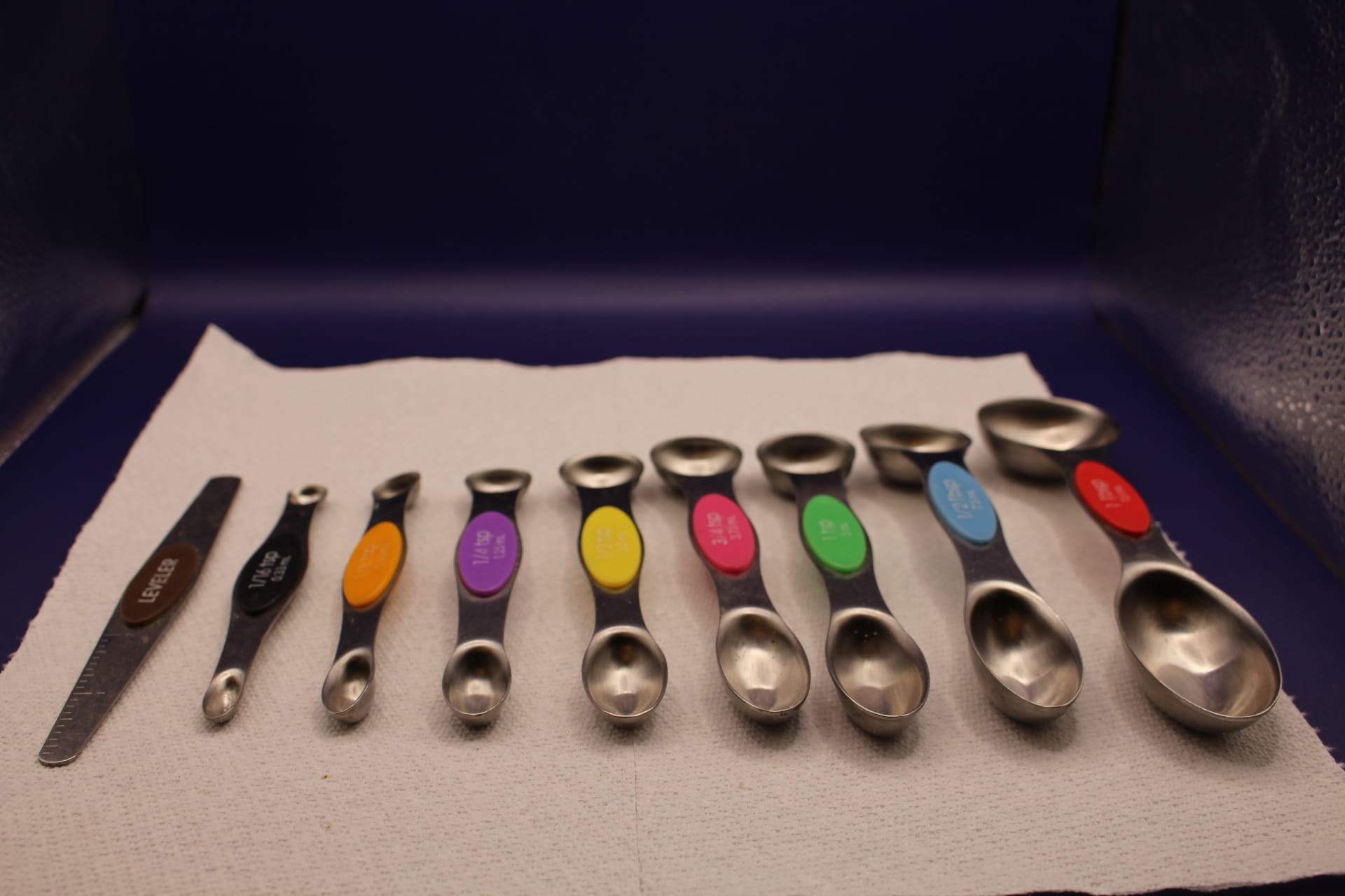 double-ended magnetic measuring spoon set with leveler tool, displayed from smallest to biggest size