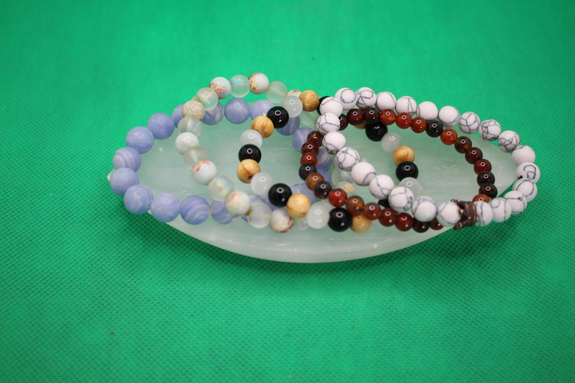 leaf-shaped selenite plate with bracelets spread out on it