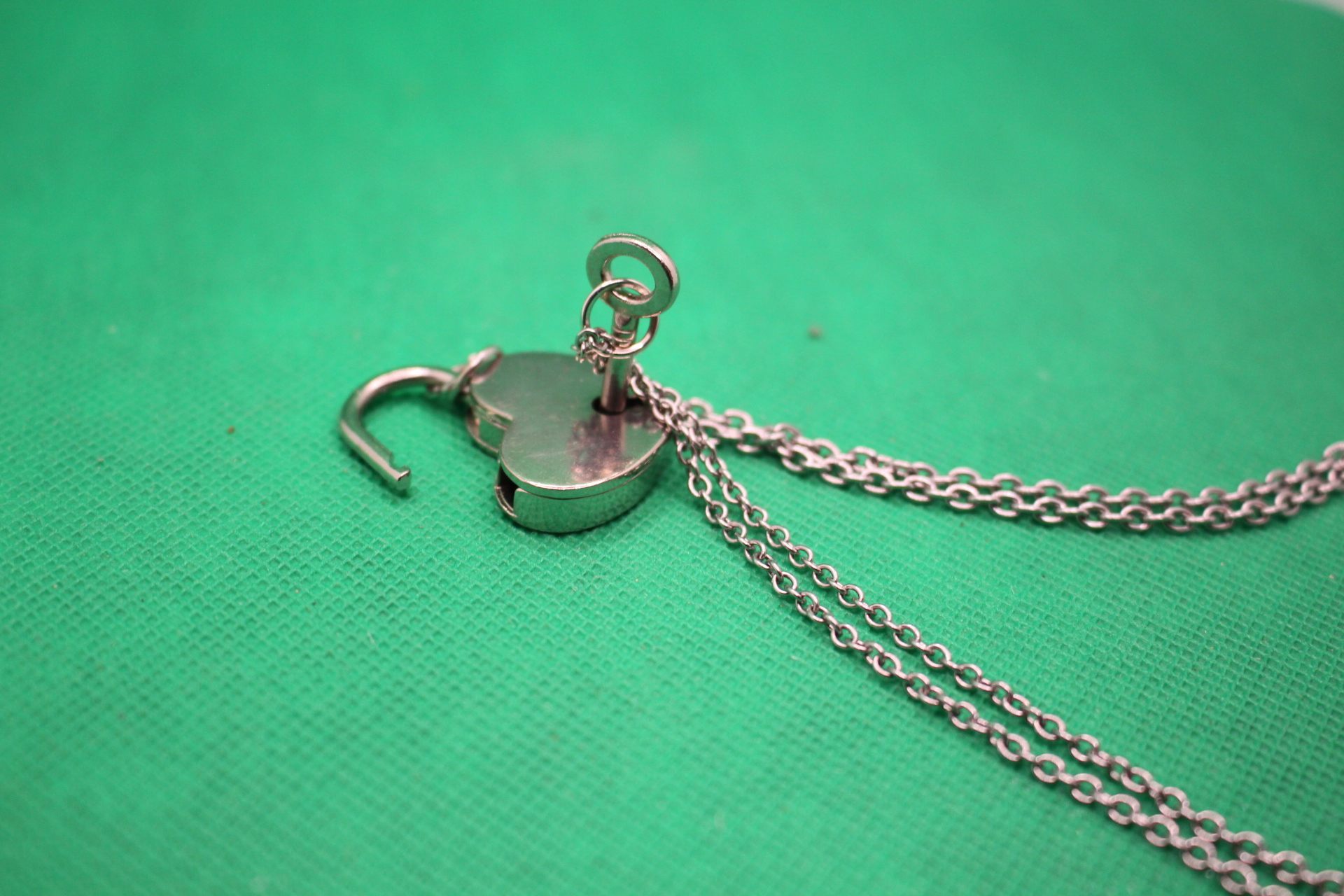 heart lock and key couple necklaces set, close-up shot of lock opened by key