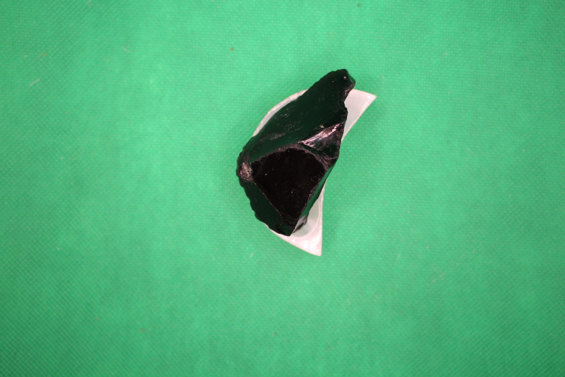 moon-shaped selenite plate with big piece of obsidian on it