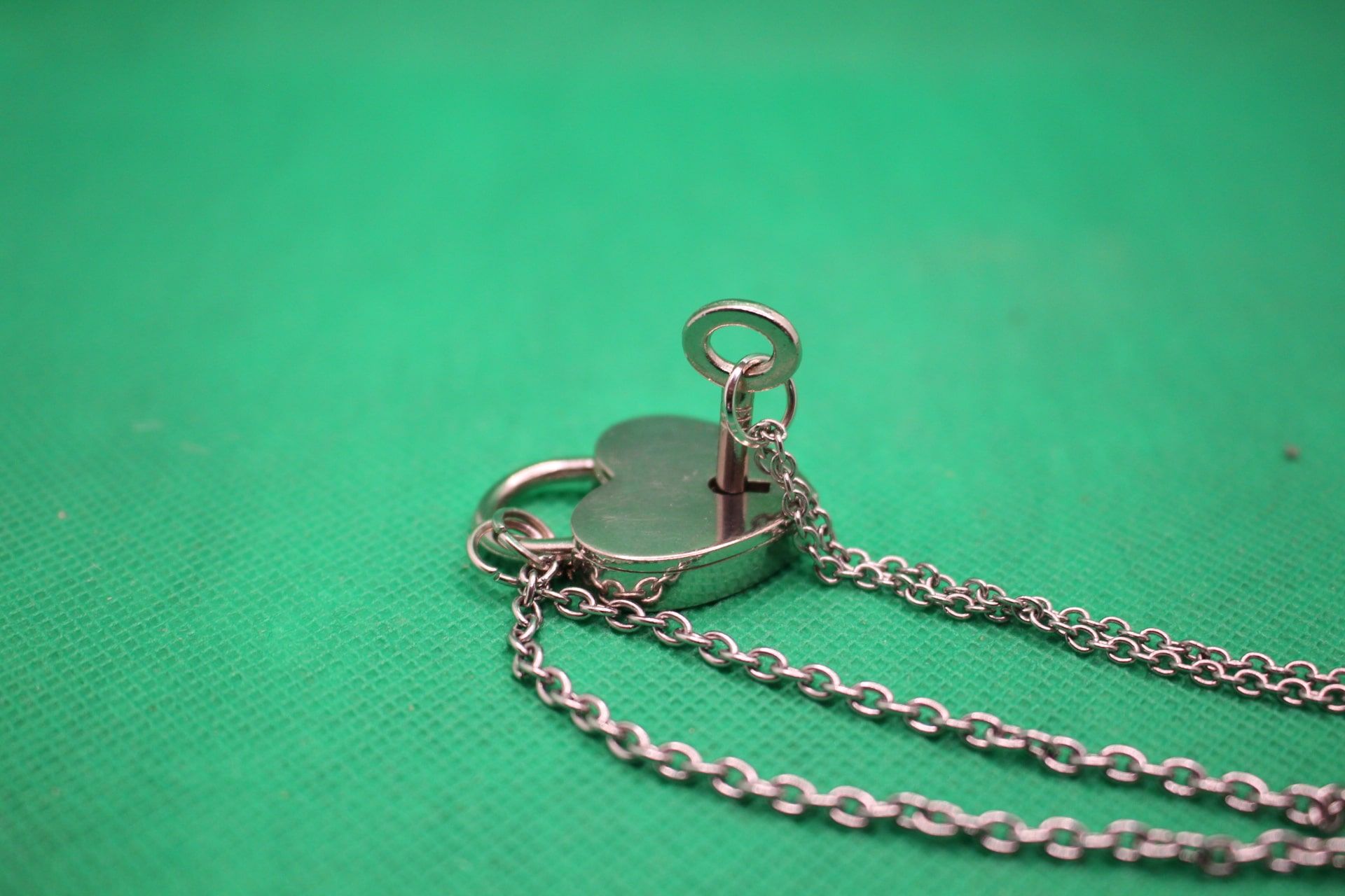 heart lock and key couple necklaces set, close-up shot of how key fits into lock