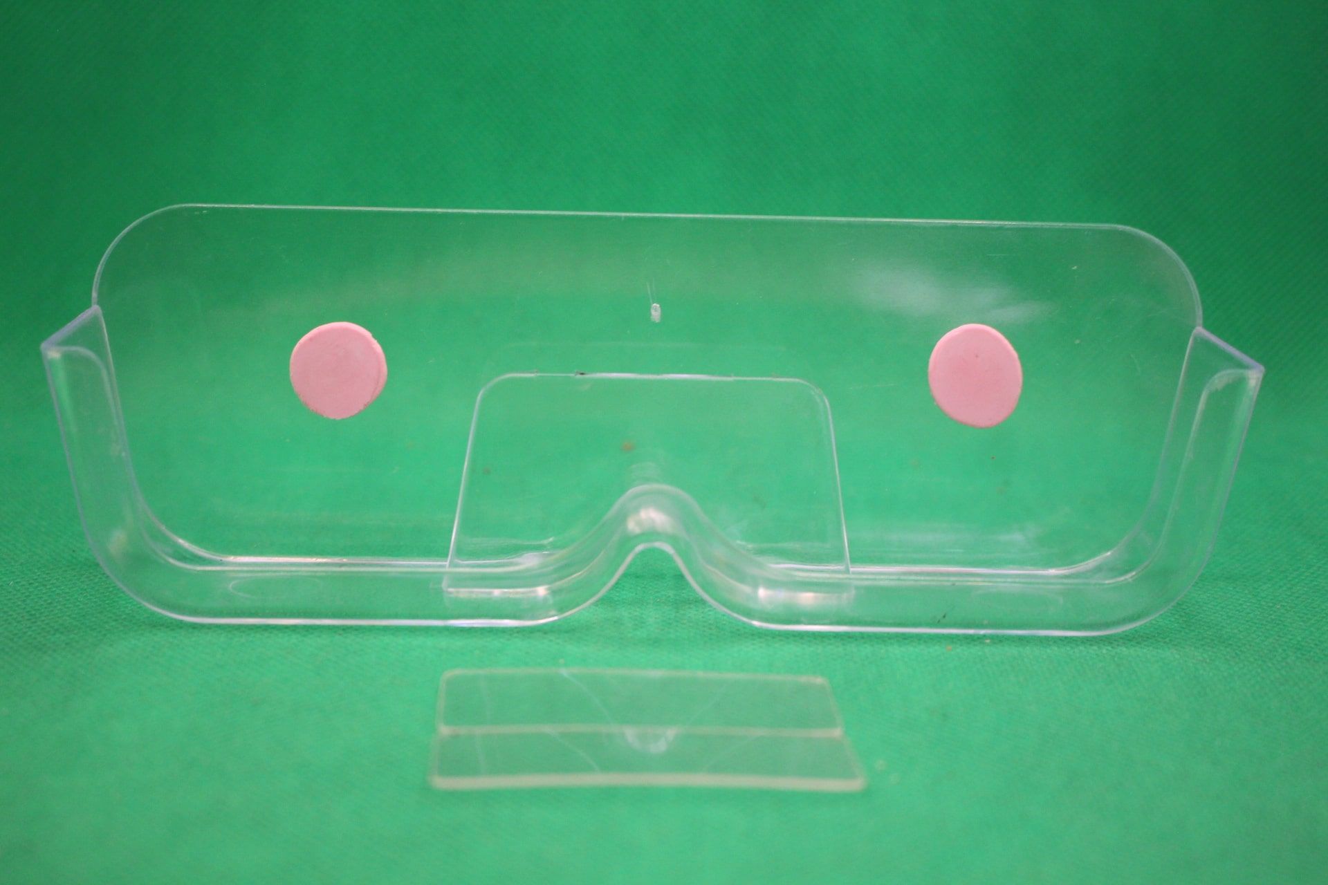 wall mounted eyeglasses holder with sticky tacky putty, and unused adhesives in front