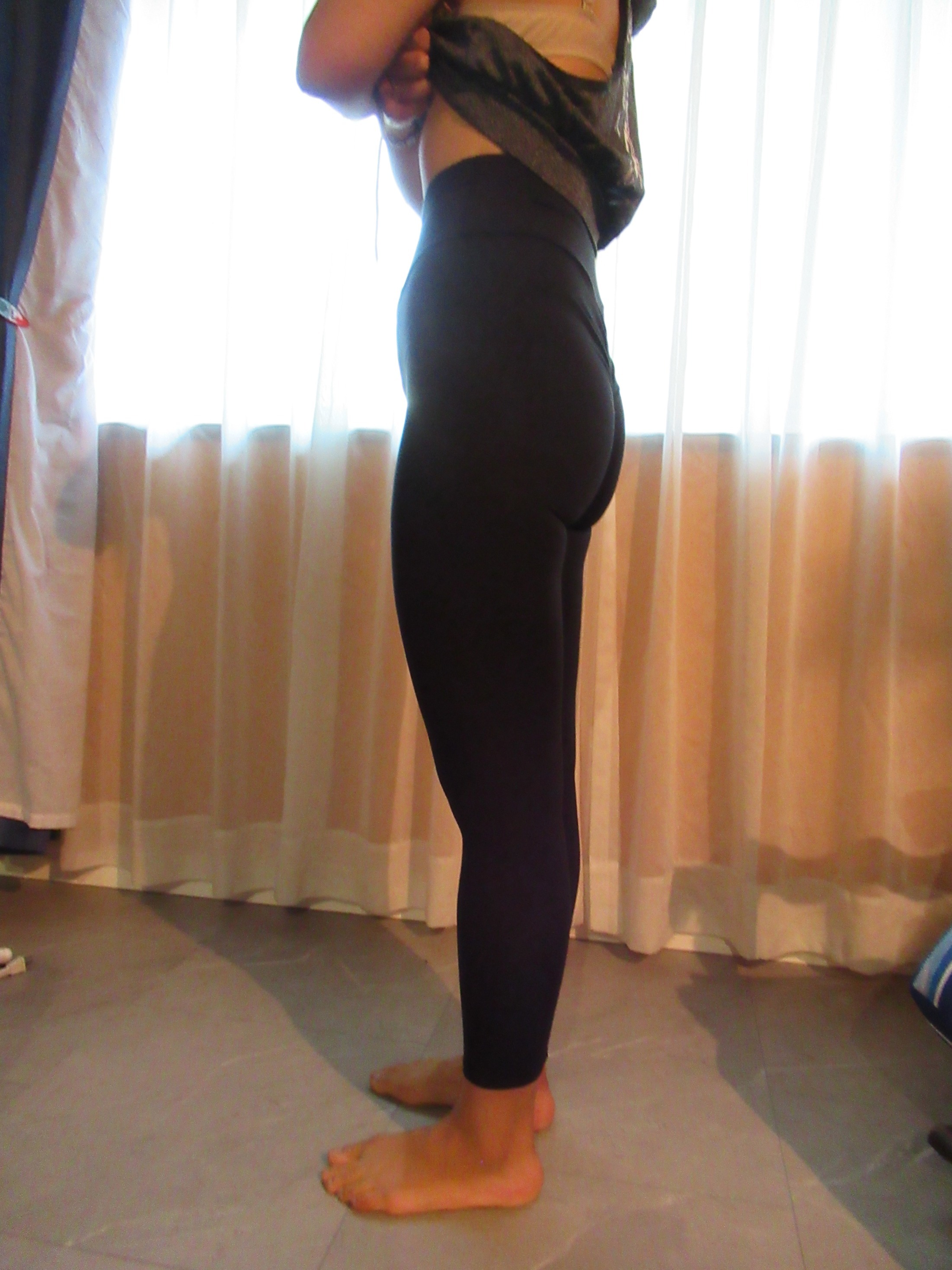 Booty scrunch butt-lifting pants with ruching -- black, left side view; trying on, modelling "scrunch butt" ruched butt-lifter on person