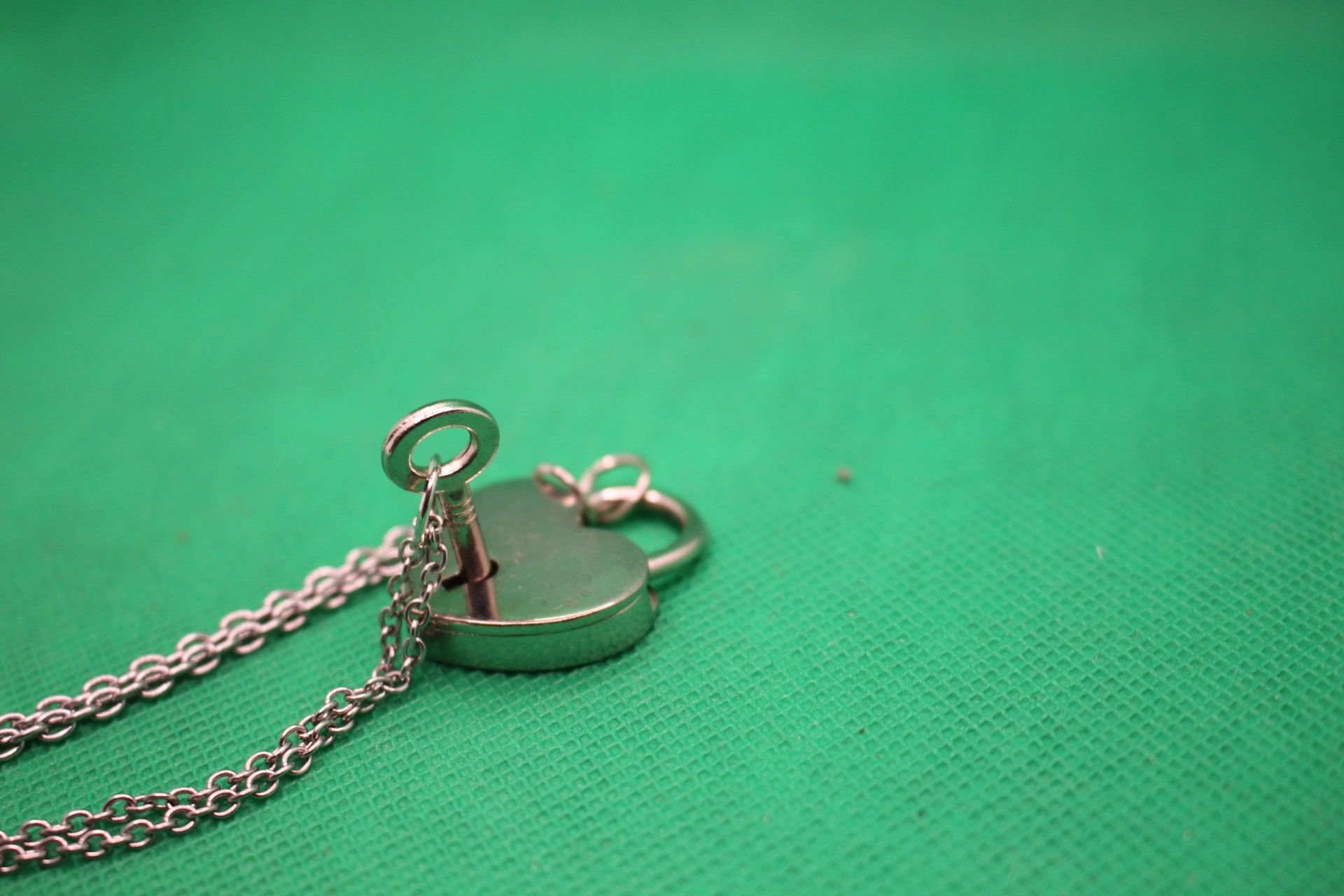 heart lock and key couple necklaces, close-up shot of how key fits into lock