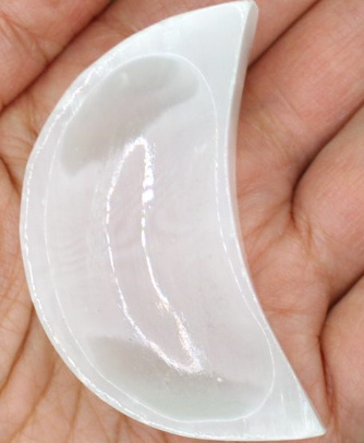 moon-shaped selenite plate on hand