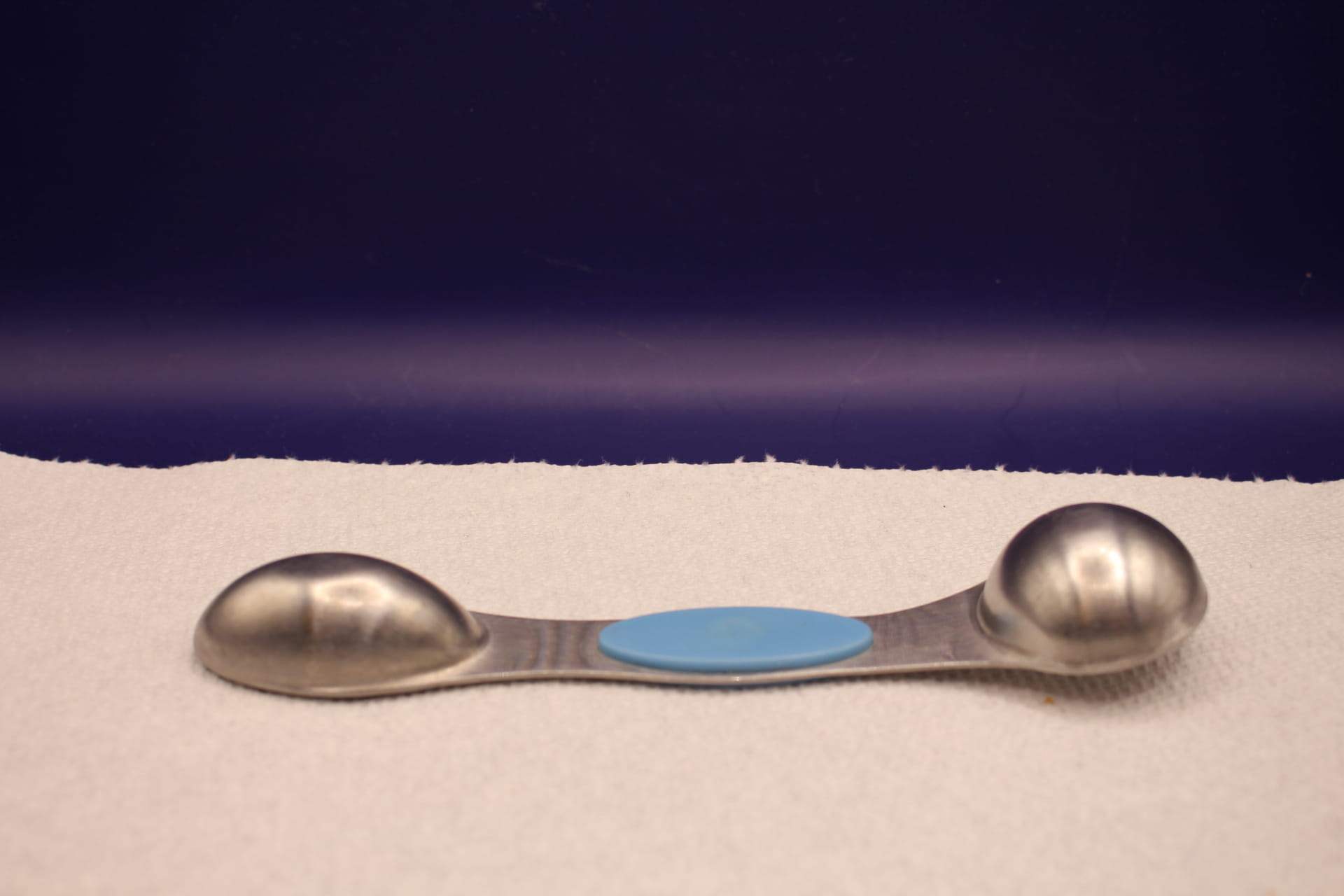 bent 1/2 tbsp two sided measuring spoon, bottom side up
