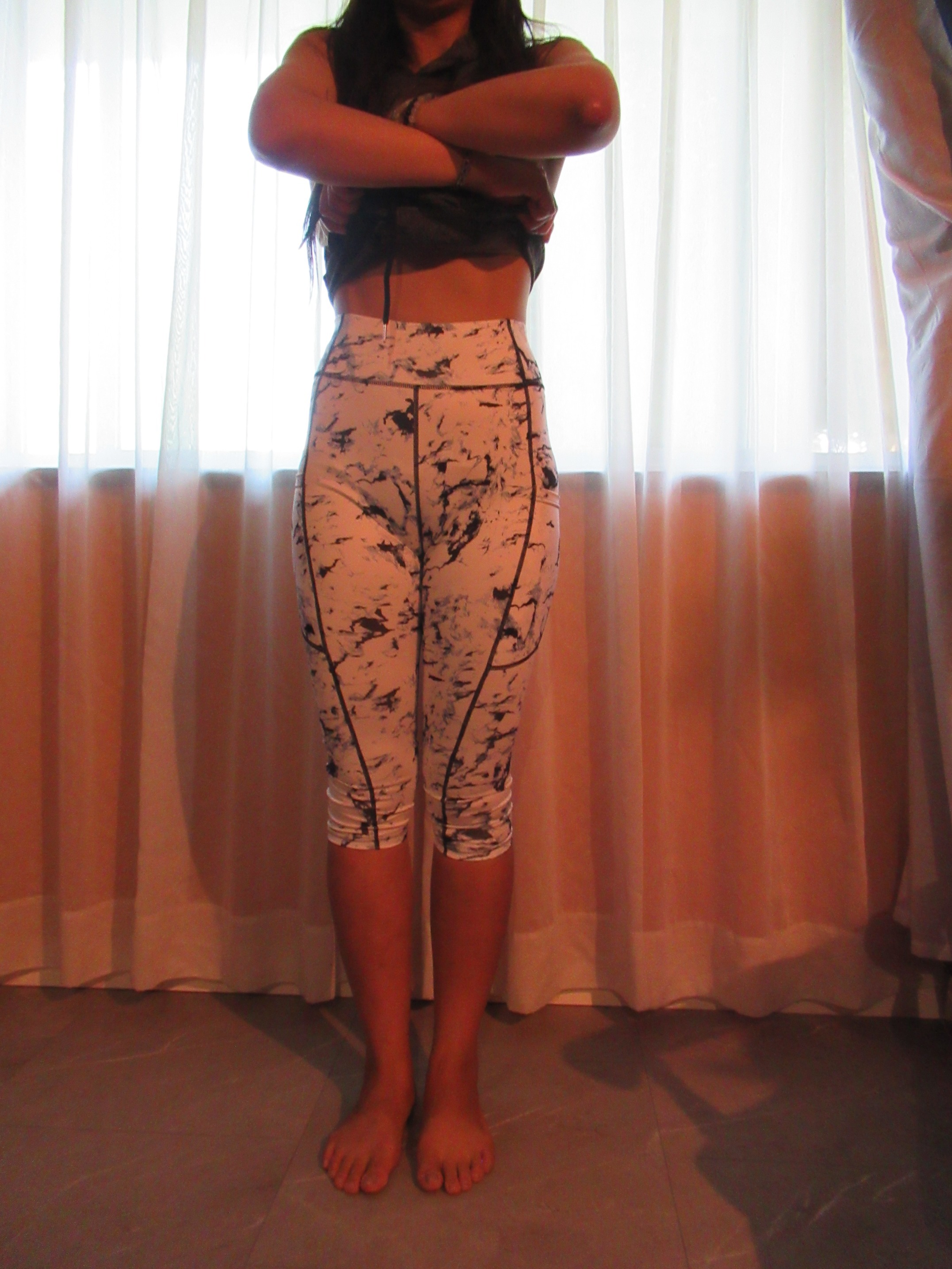 butt-lifting capri pants with big pockets set of three -- white with black splash design, front view; trying on, modelling butt-lifter capris on person