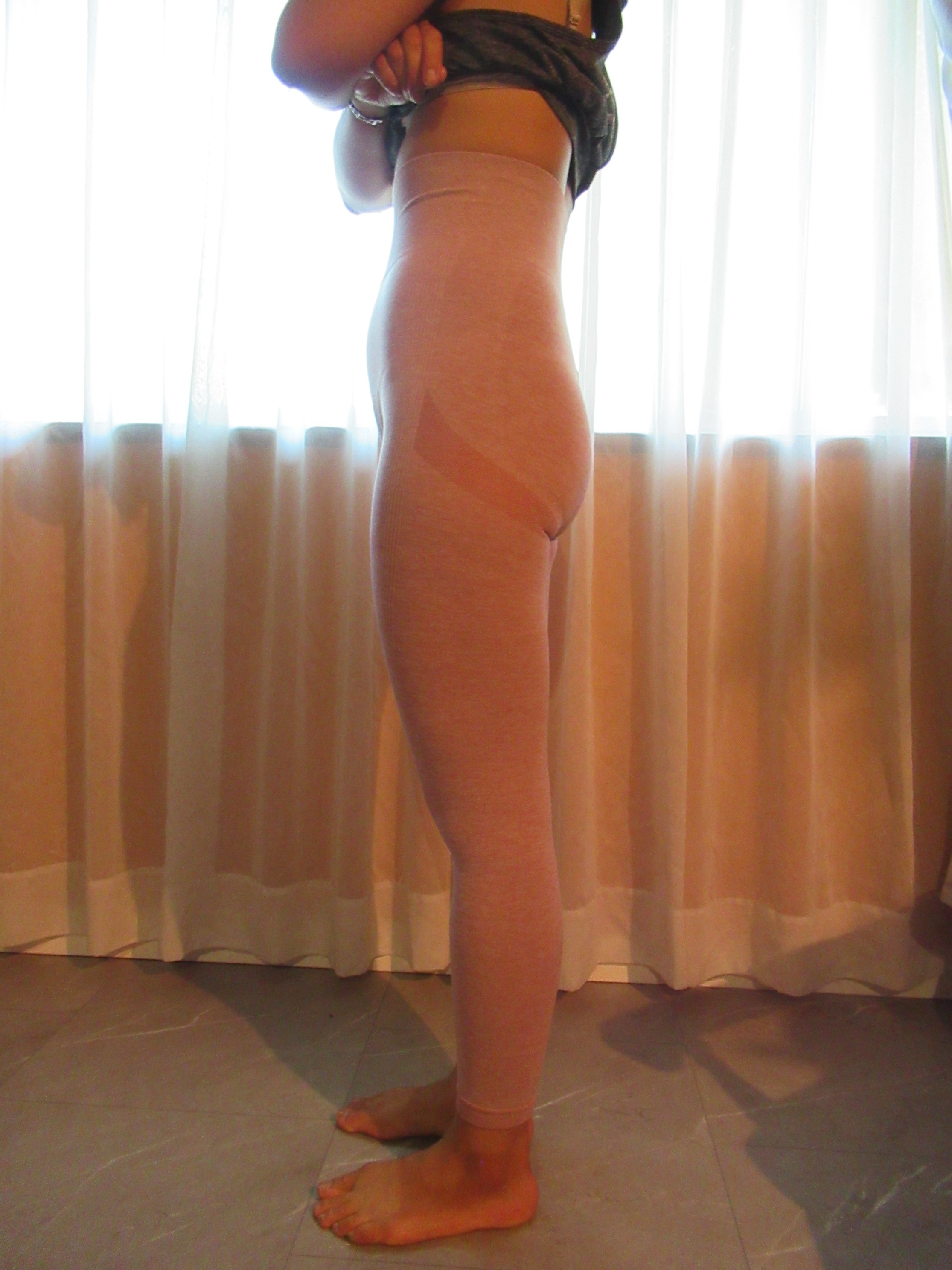 peach lift butt-lifting leggings -- pink, left side view; trying on, modelling peach-lift butt-lifter on person