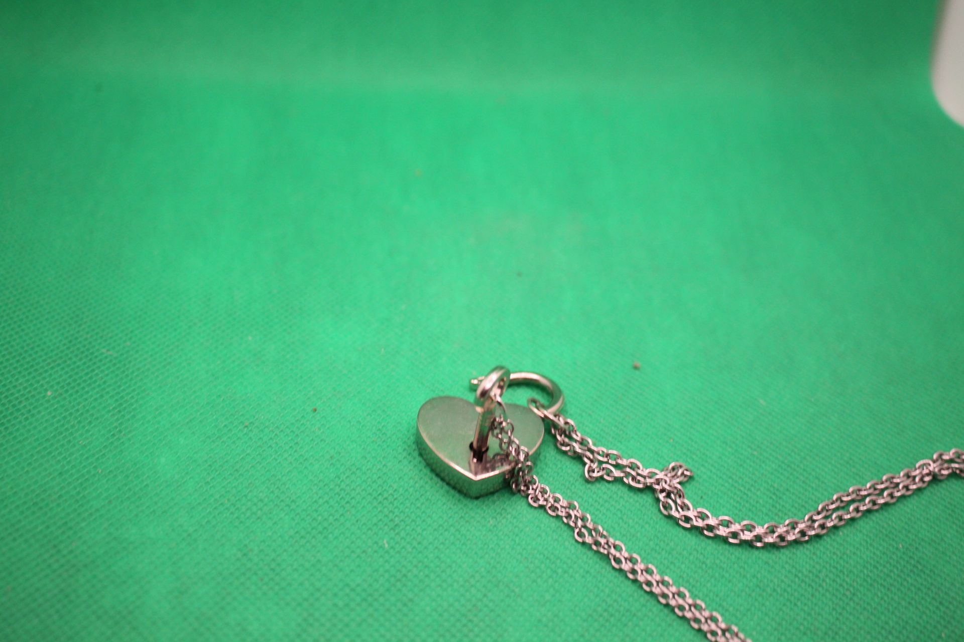 heart lock and key couple necklace set, close-up shot of how key fits into lock