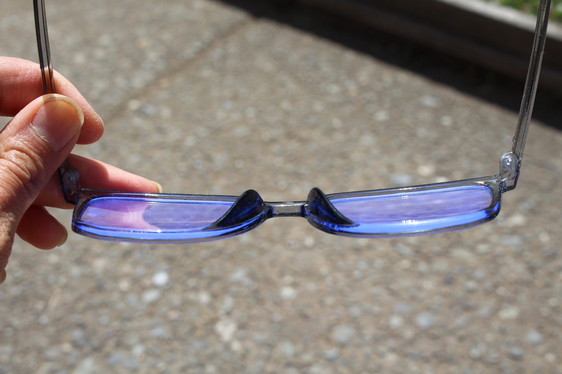 blue-light-filtering glasses reflecting a blue glow under the sun
