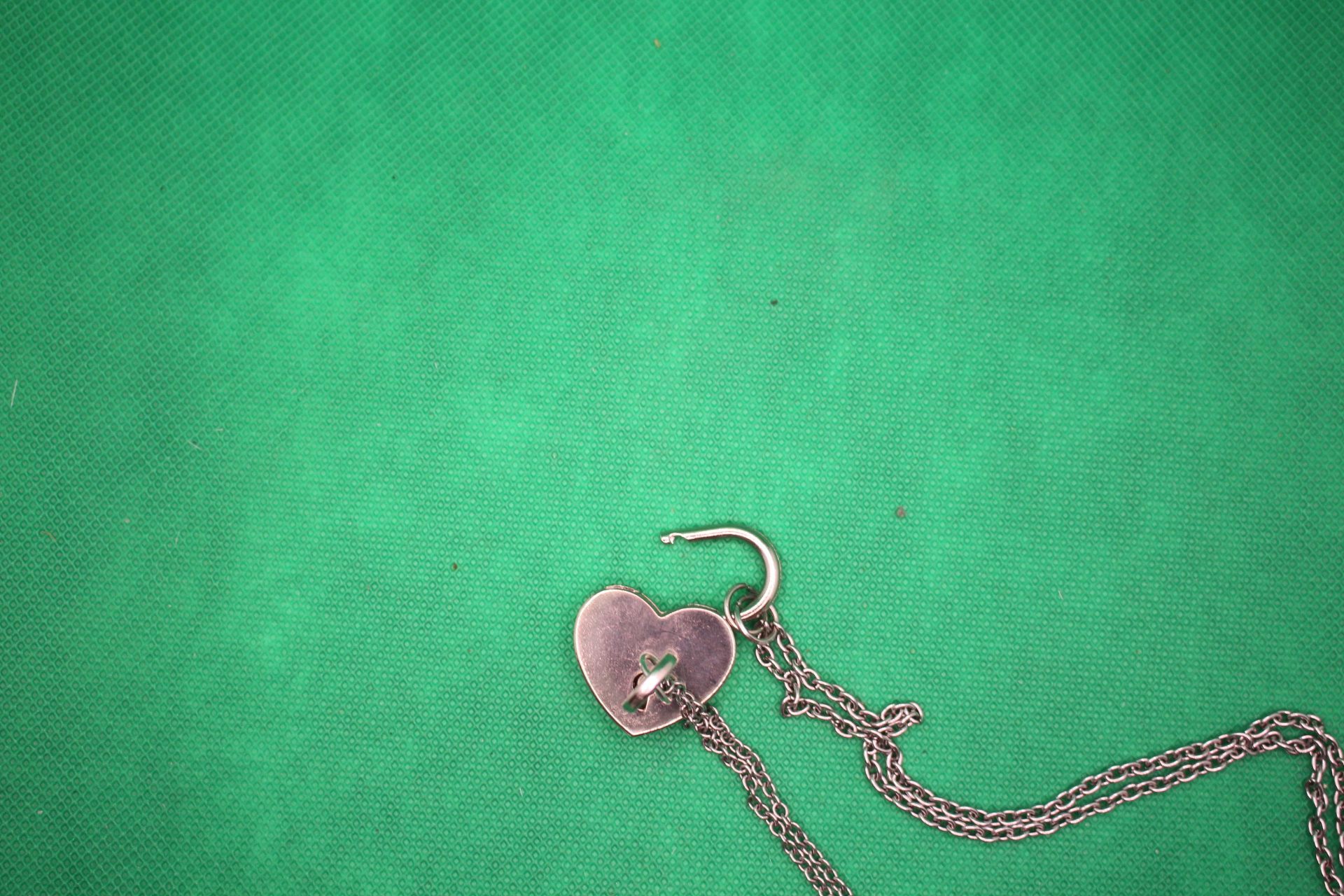 heart lock and key couple necklaces, close-up shot of lock opened by key