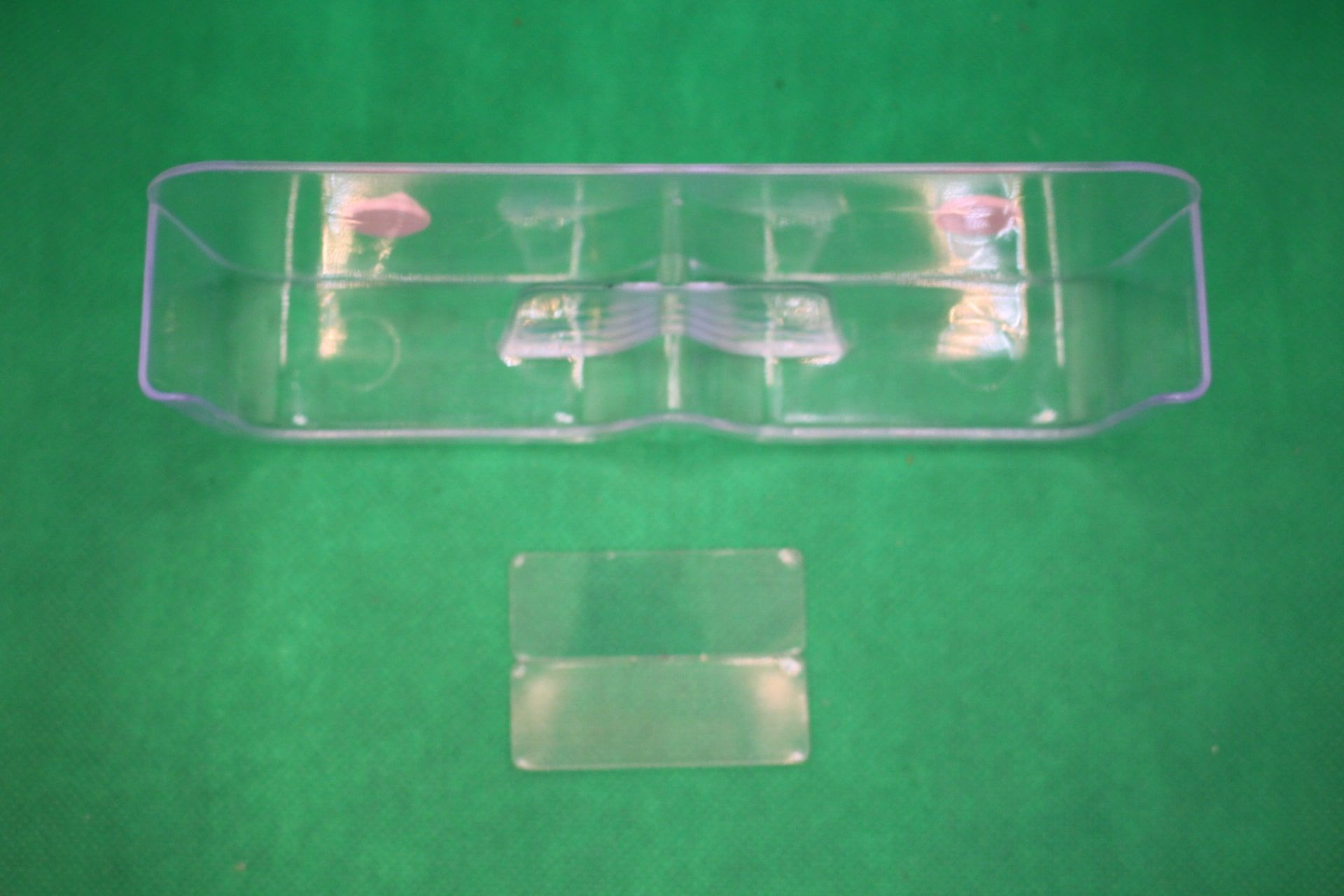 wall mounted eyeglasses holder with sticky tacky putty, overhead view, and unused adhesives in front
