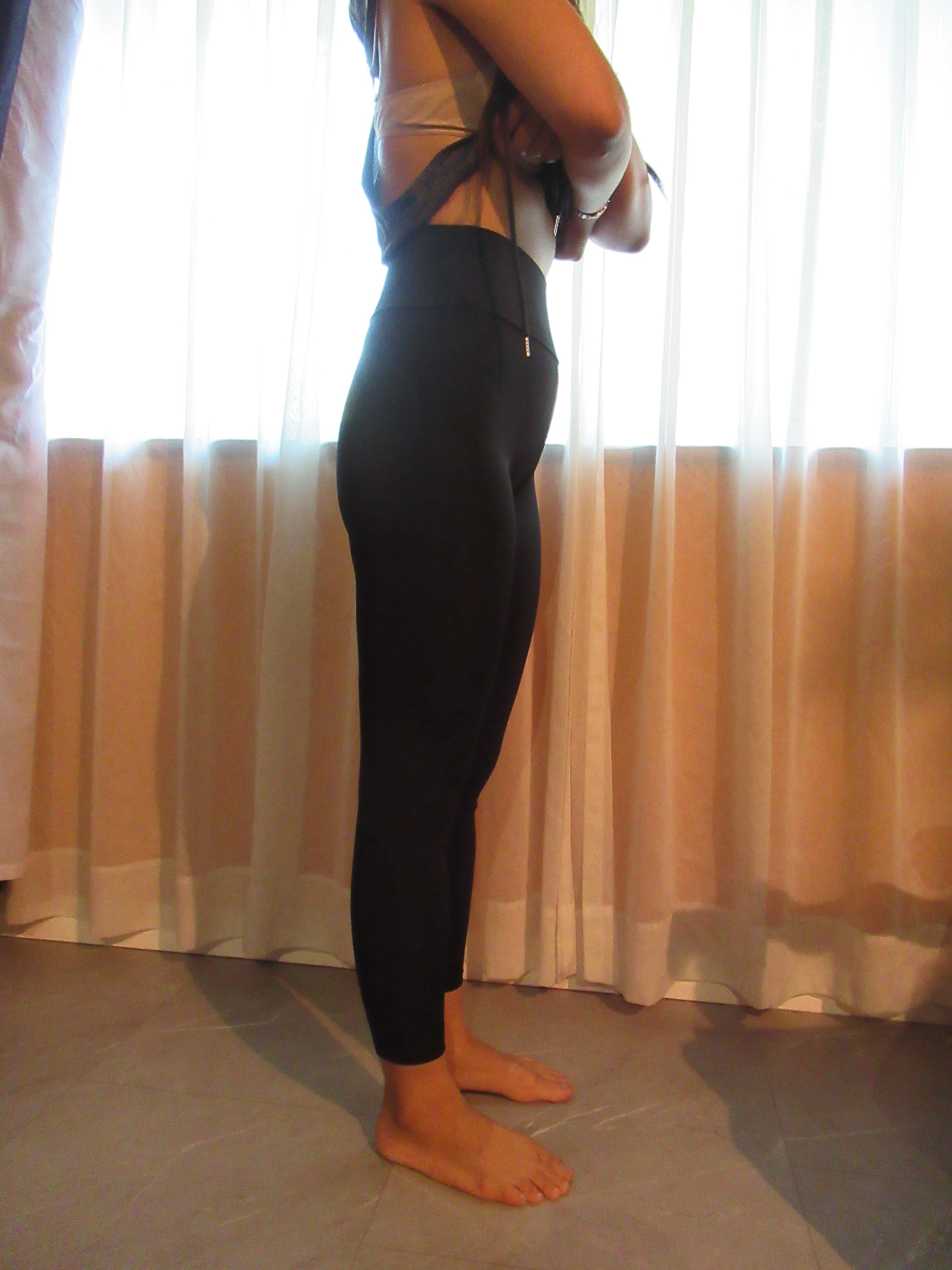 butt-lifting bike pants / yoga leggings -- black, right side view; trying on, modelling biking butt-lifter on person