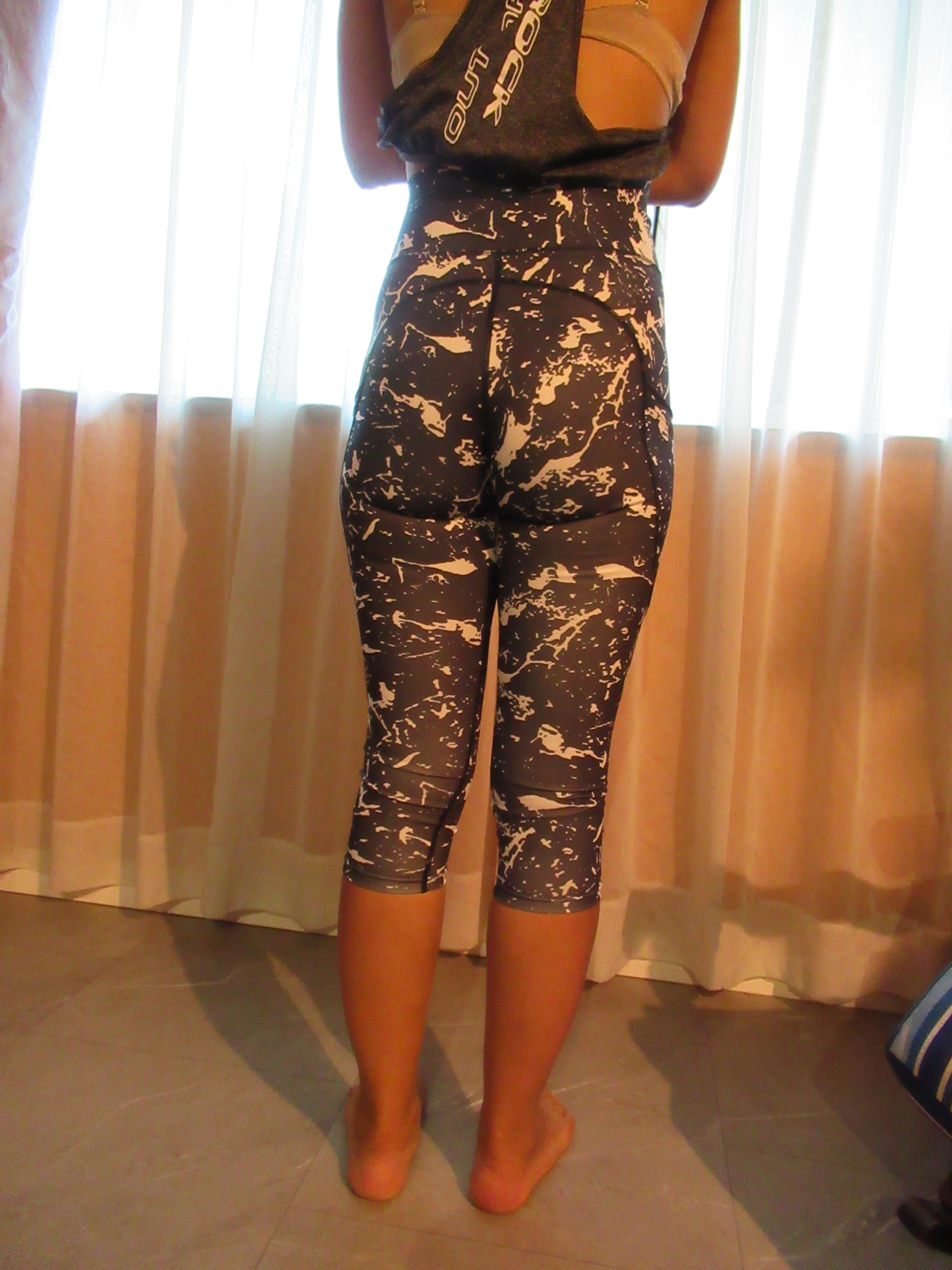 butt-lifting capri pants with big pockets set of three -- black with white splash design, back view; trying on, modelling butt-lifter capris on person