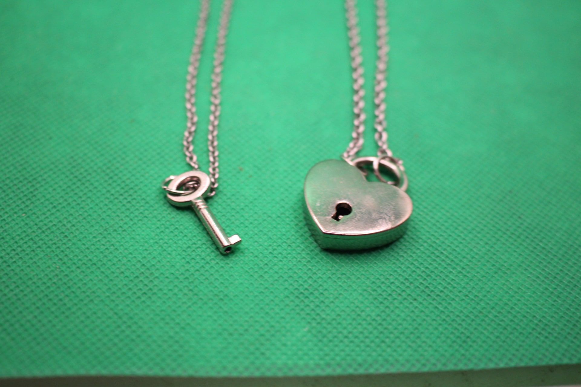 heart lock and key couple necklaces, close-up shot of pendants